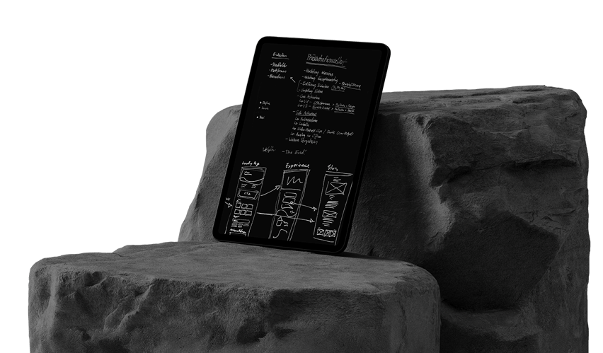 Tablet computer with handwritten notes lies on a stone
